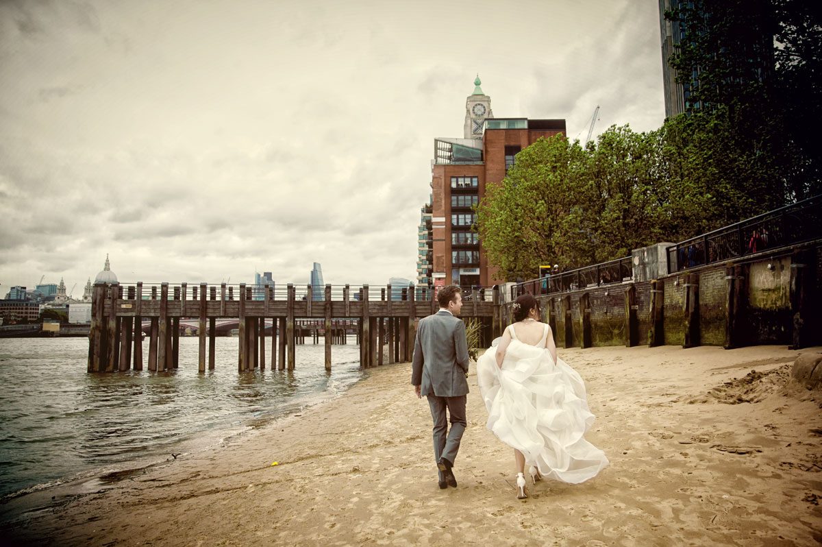 Wedding couple walk on beach at South Bank to Oxo Tower image