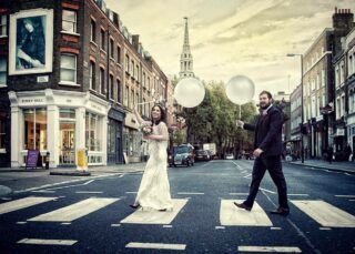 Couple with balloons on Upper Street crossing at Islington Town Hall wedding