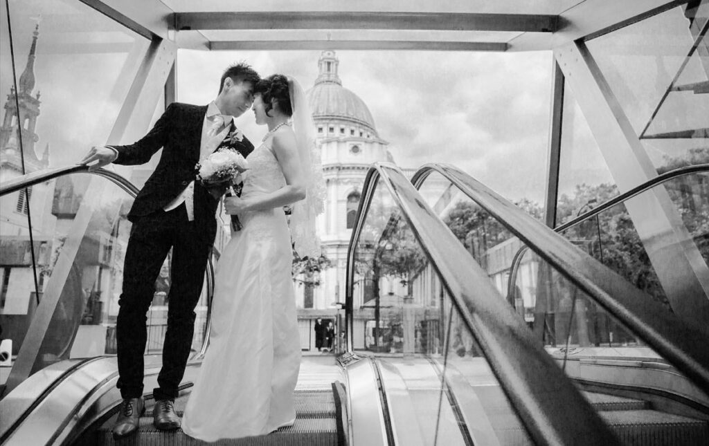 Bride and groom on escalator by London St Pauls Cathedral