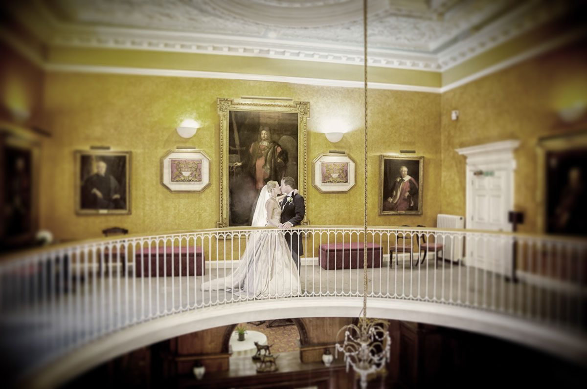 Couple kiss on balcony at their Skinners Hall wedding reception image