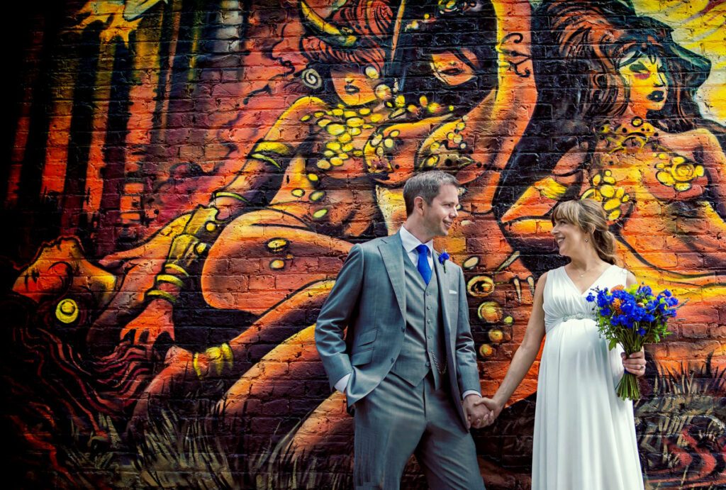 East London wedding couple in front of graffiti photo