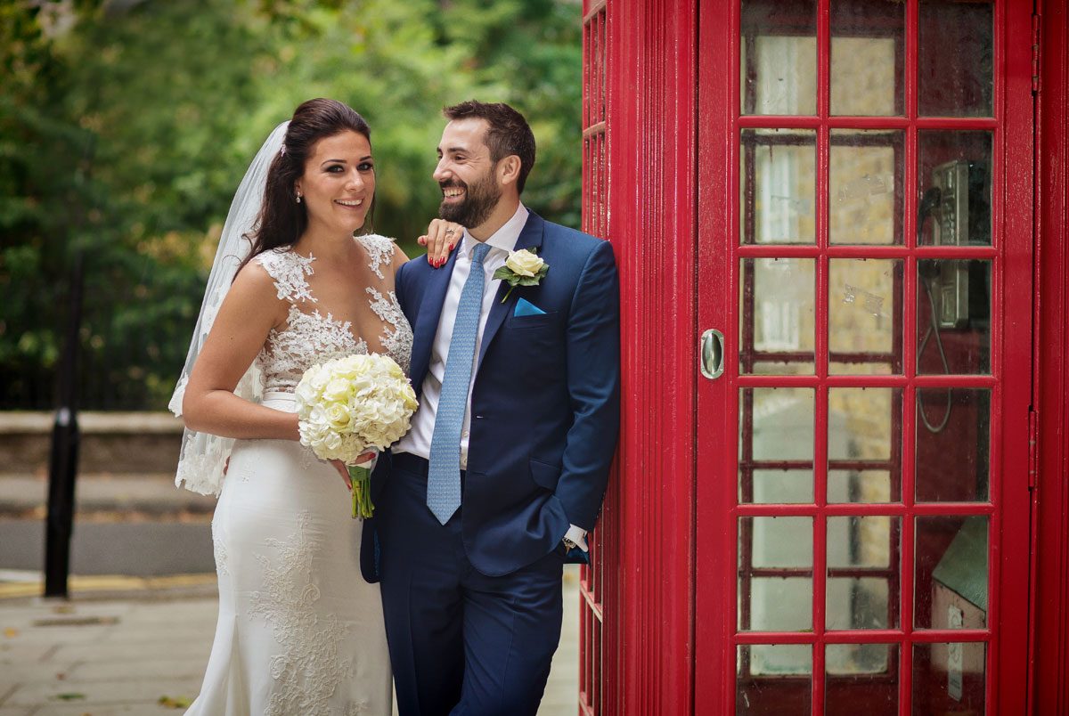 Wedding couple by red phone box Chelsea and St Lukes