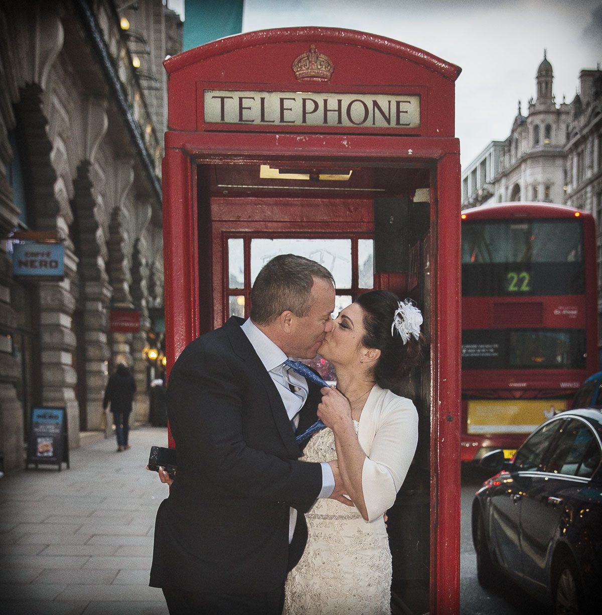 Wedding couple kiss inside red London phone box image