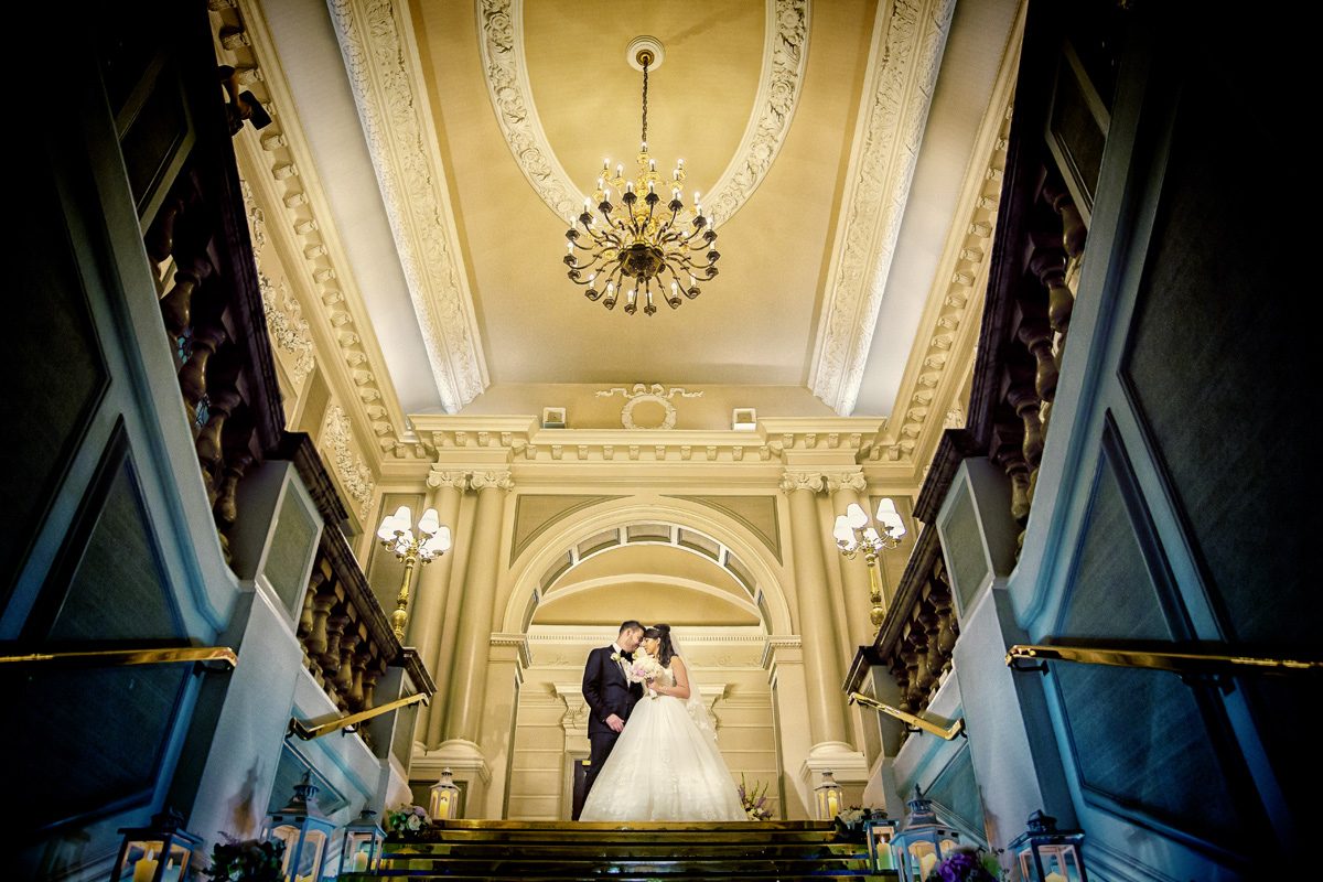 Bride and groom on stairs at London Connaught Rooms wedding day
