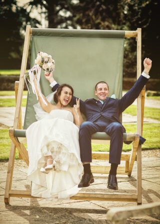 Wedding couple in big deckchair at Hanbury Manor