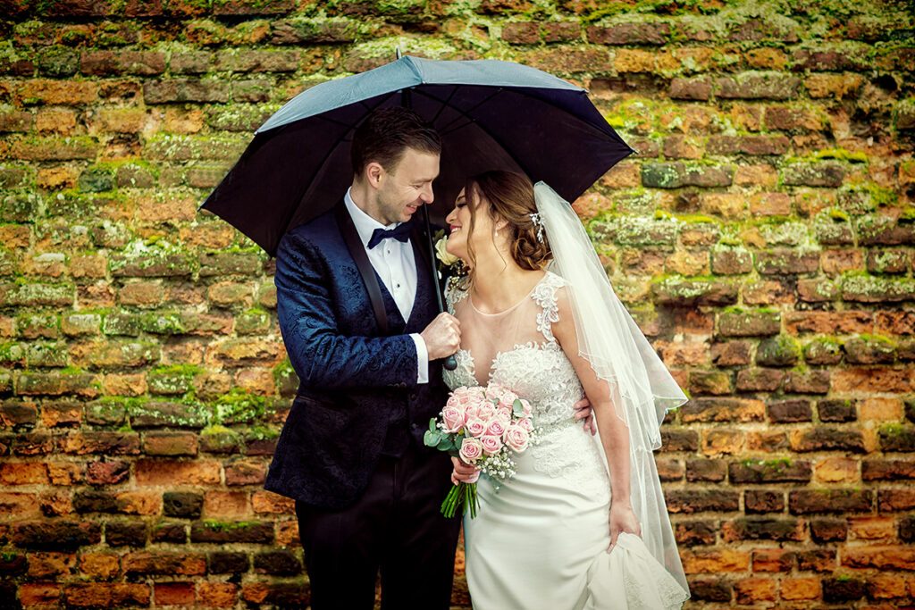 London wedding couple laugh together under umbrella