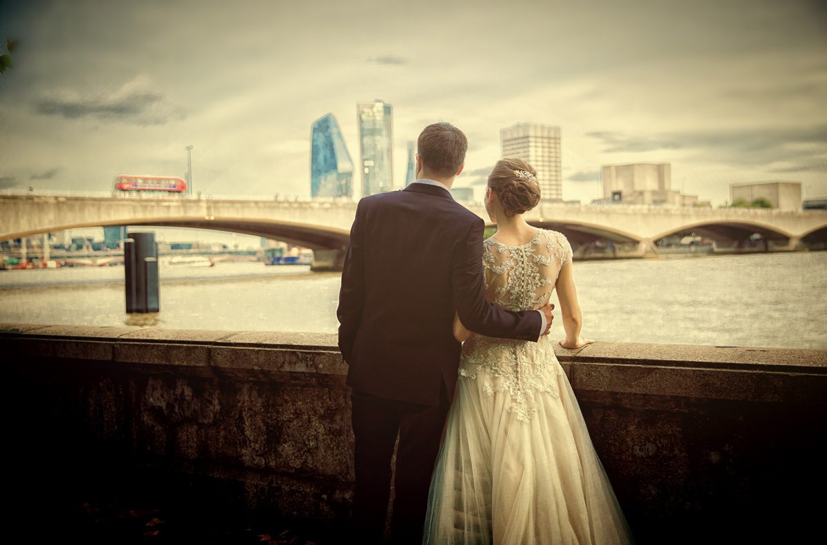 Wedding couple look across the Thames towards Waterloo bridge