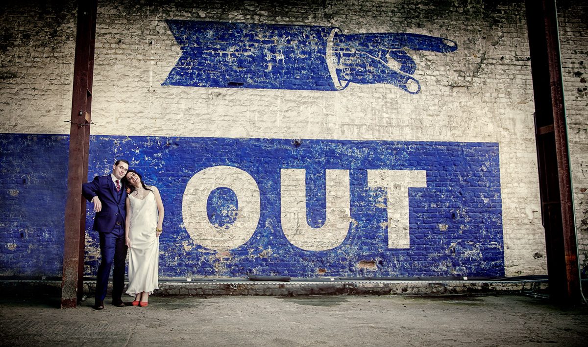 Bride and groom by sign at Trinity Buoy Wharf Wedding