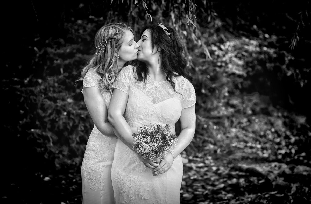 Two brides kiss at London Gay Wedding day image