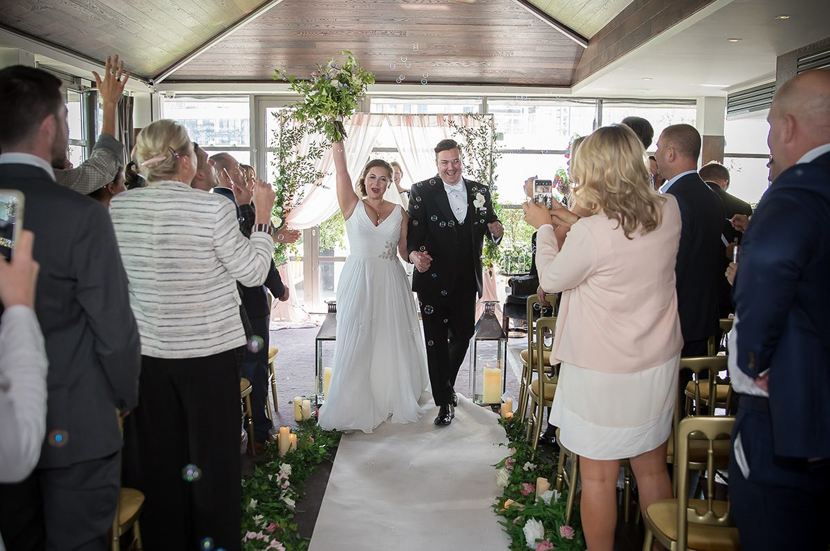 Bride and groom in aisle at Eight Club wedding ceremony