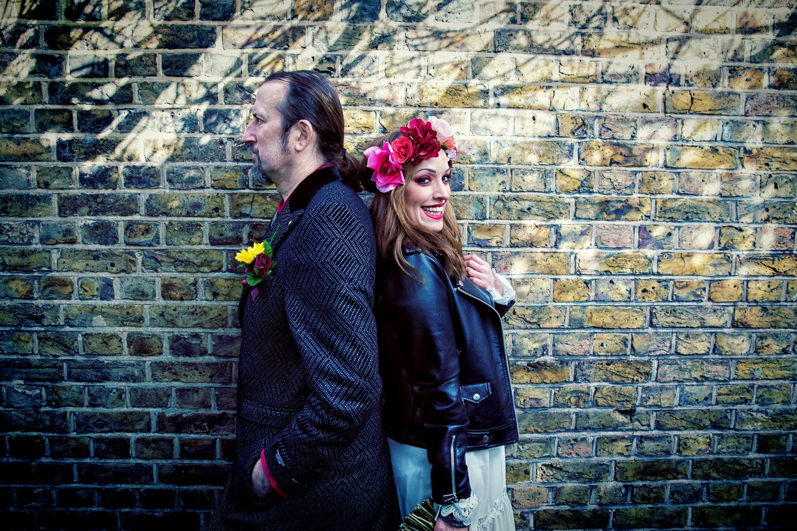 Islington wedding couple back to back by brick wall central London