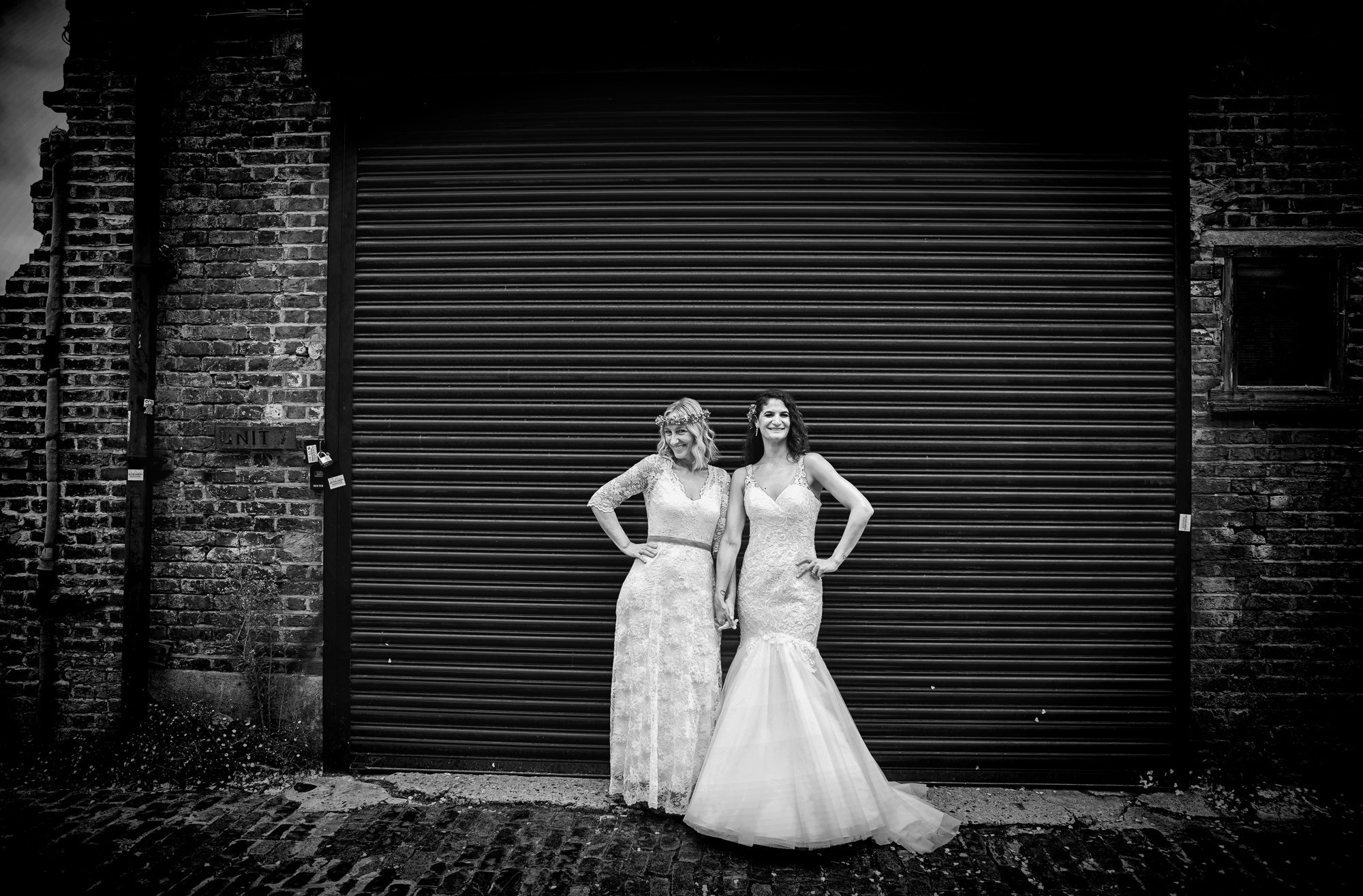 Two brides black roller doors Clapton Country Club wedding London