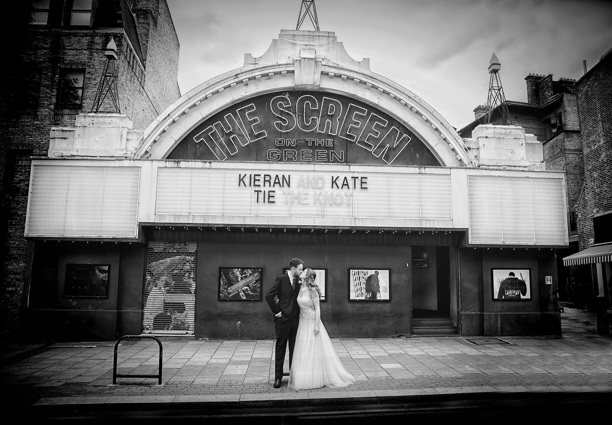 Wedding couple kiss in front of Islington Screen on the Green