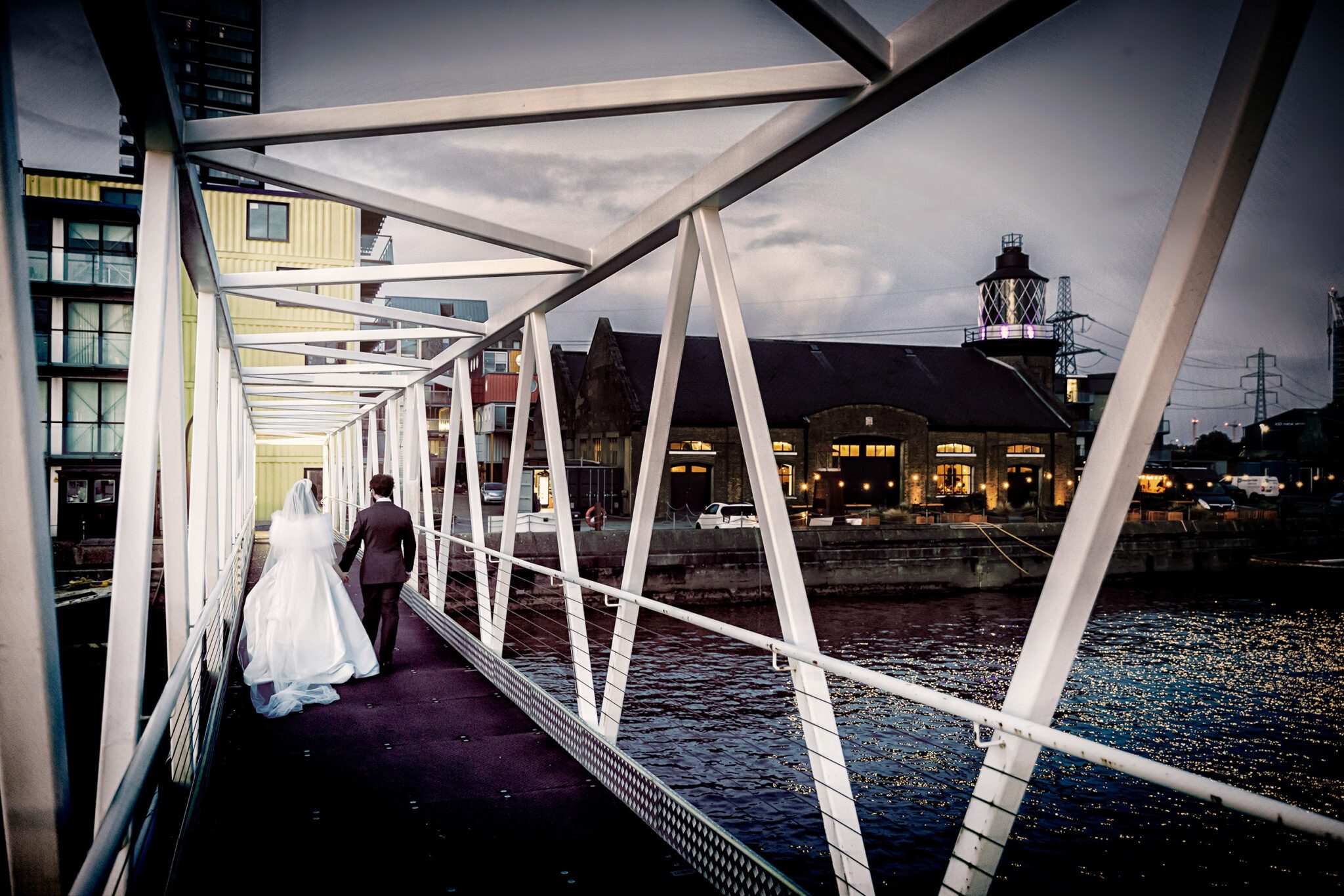 Bride and groom walk towards Trinity Buoy Wharf wedding